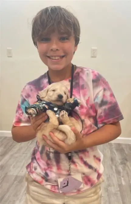 Boy holding a dressed up puppy