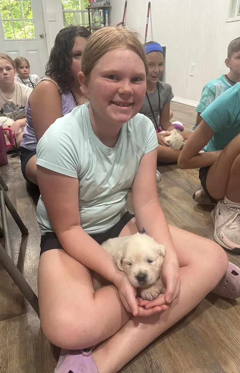 Girl giving puppy a treat