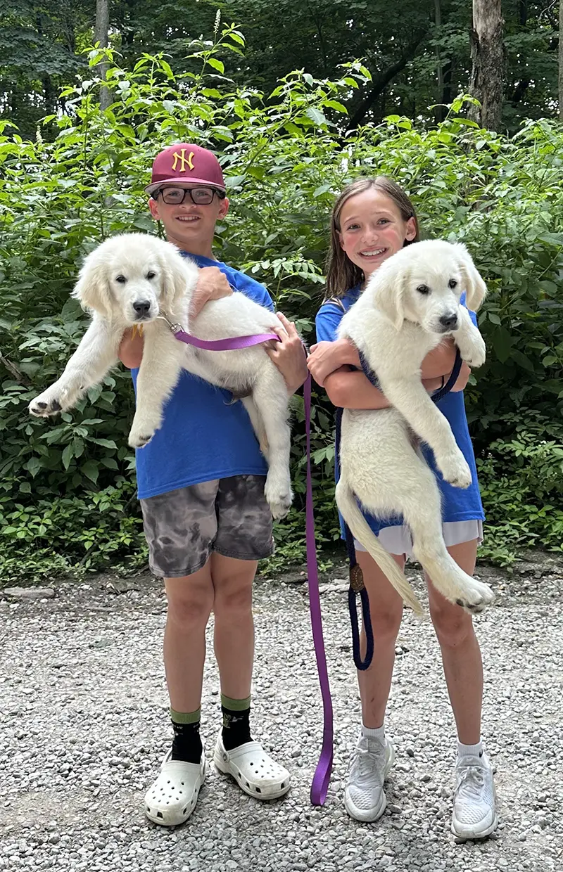 Students hold up puppy scarfs